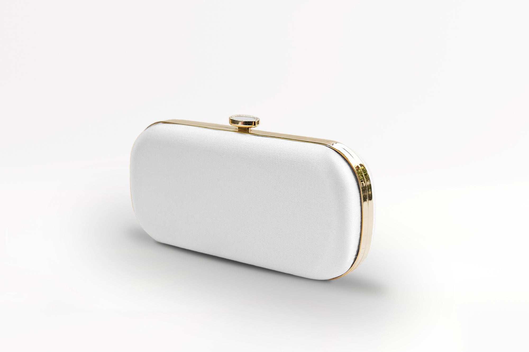 A white clutch bag on a white surface.