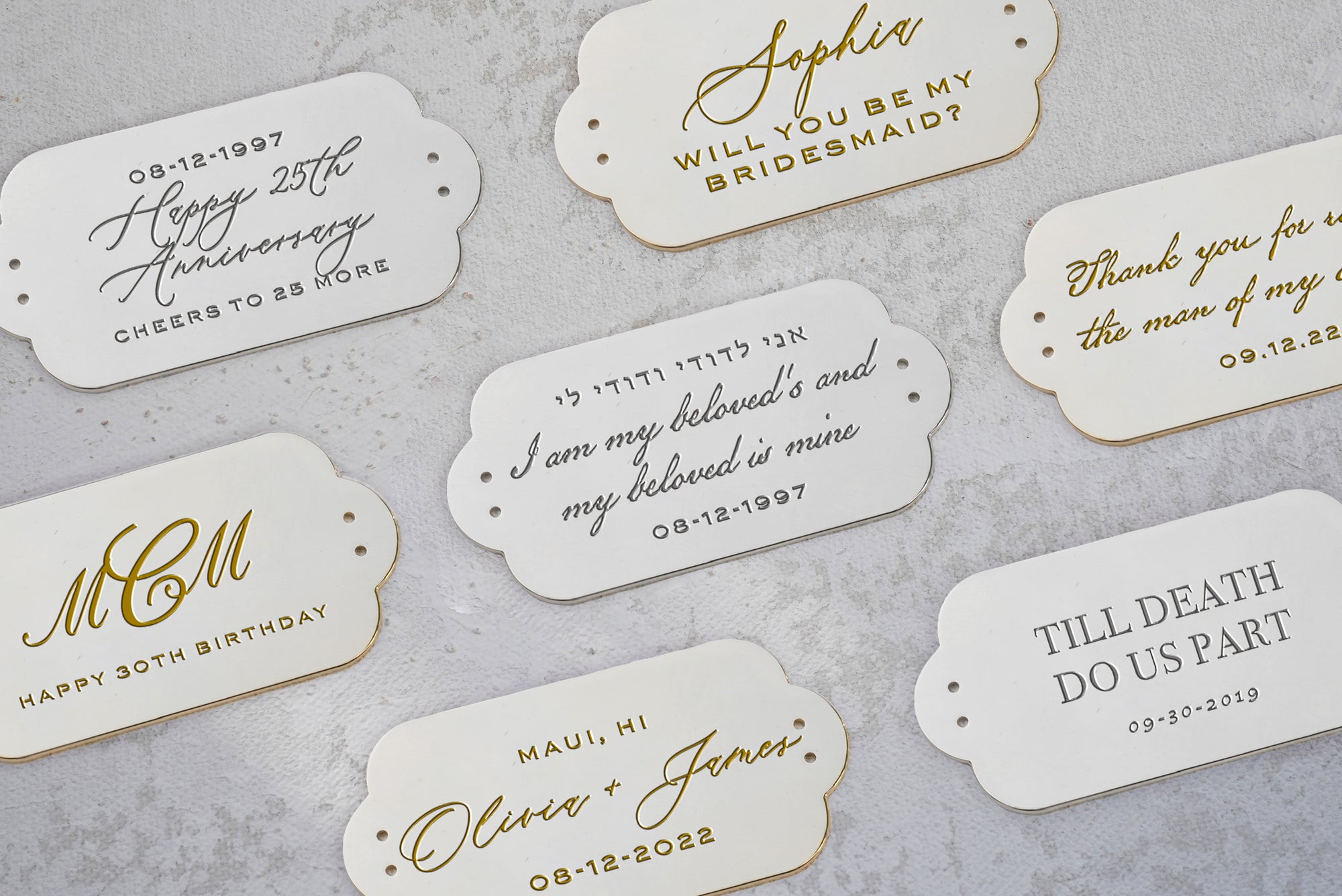 A collection of elegantly handwritten event-themed cards with gold edges on a textured surface.