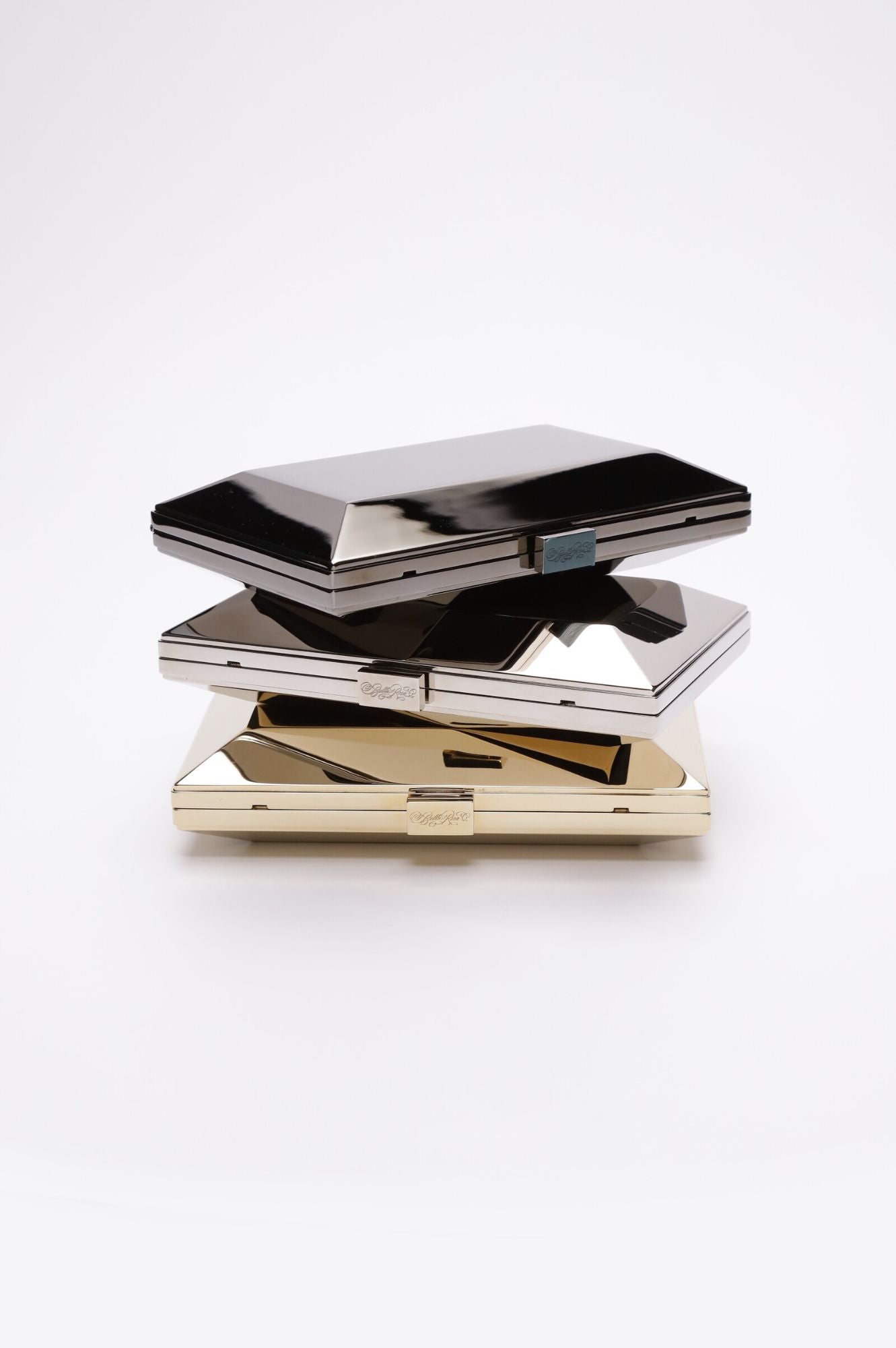 Three Milan Clutches stacked on top of each other against a white background.