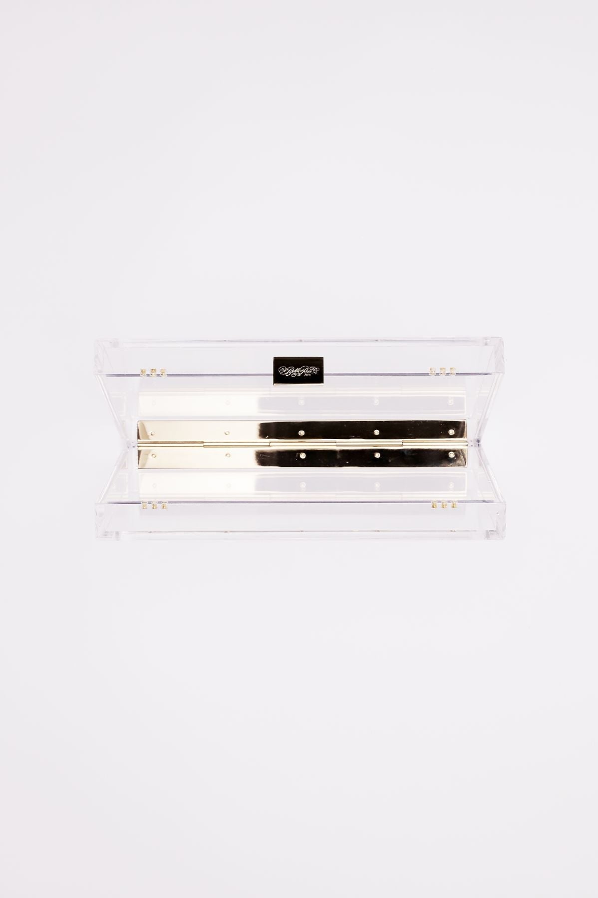 The Mia Acrylic Clutch from The Bella Rosa Collection is a clear rectangular box with gold-toned hardware and a back hinge. Its elegant design pairs beautifully with any outfit, effortlessly embodying modern sophistication.