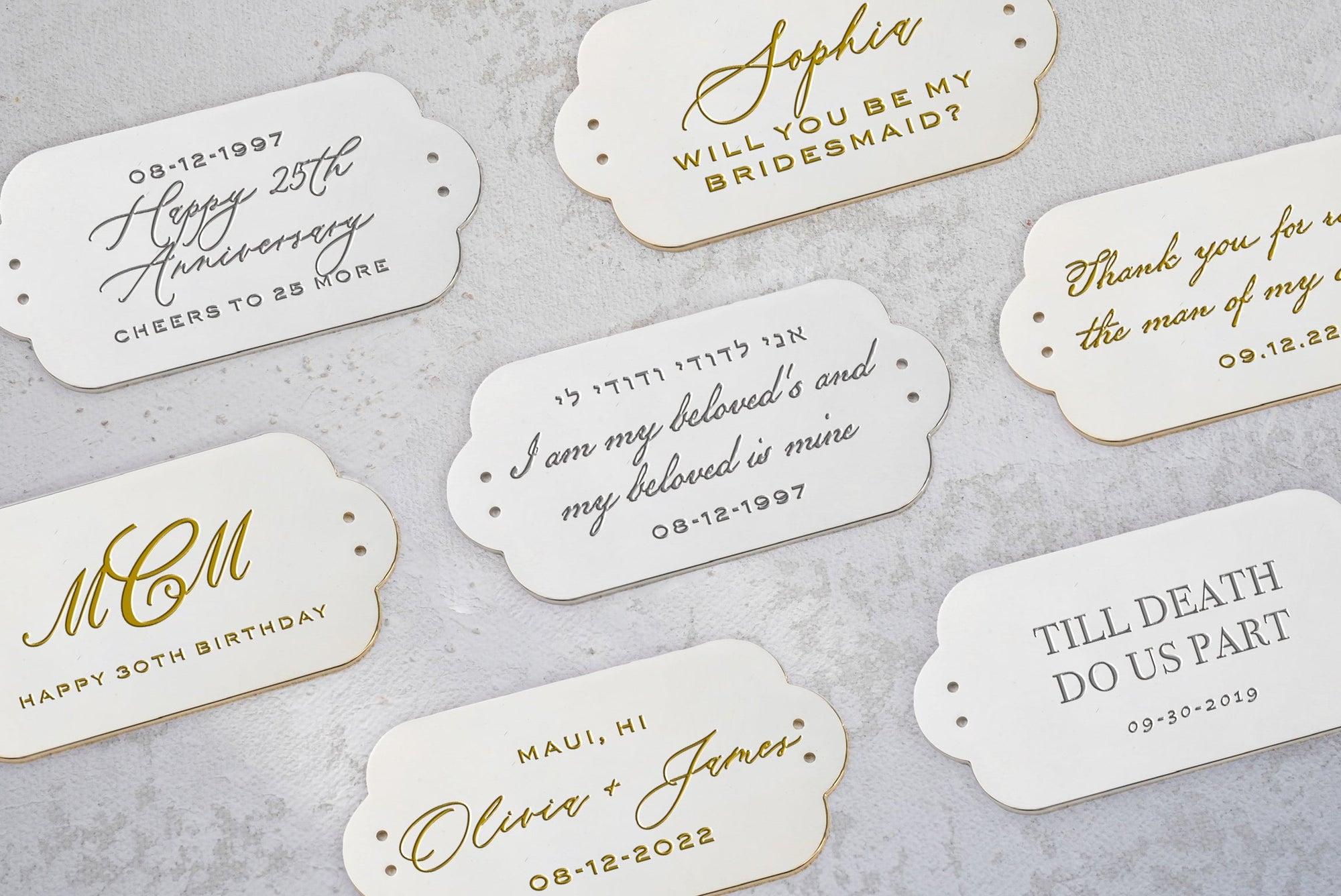 Assorted personalized Bella Clutch Sage Green Satin Petite wedding handbag event cards with gold lettering and edges displayed on a marble surface by The Bella Rosa Collection.