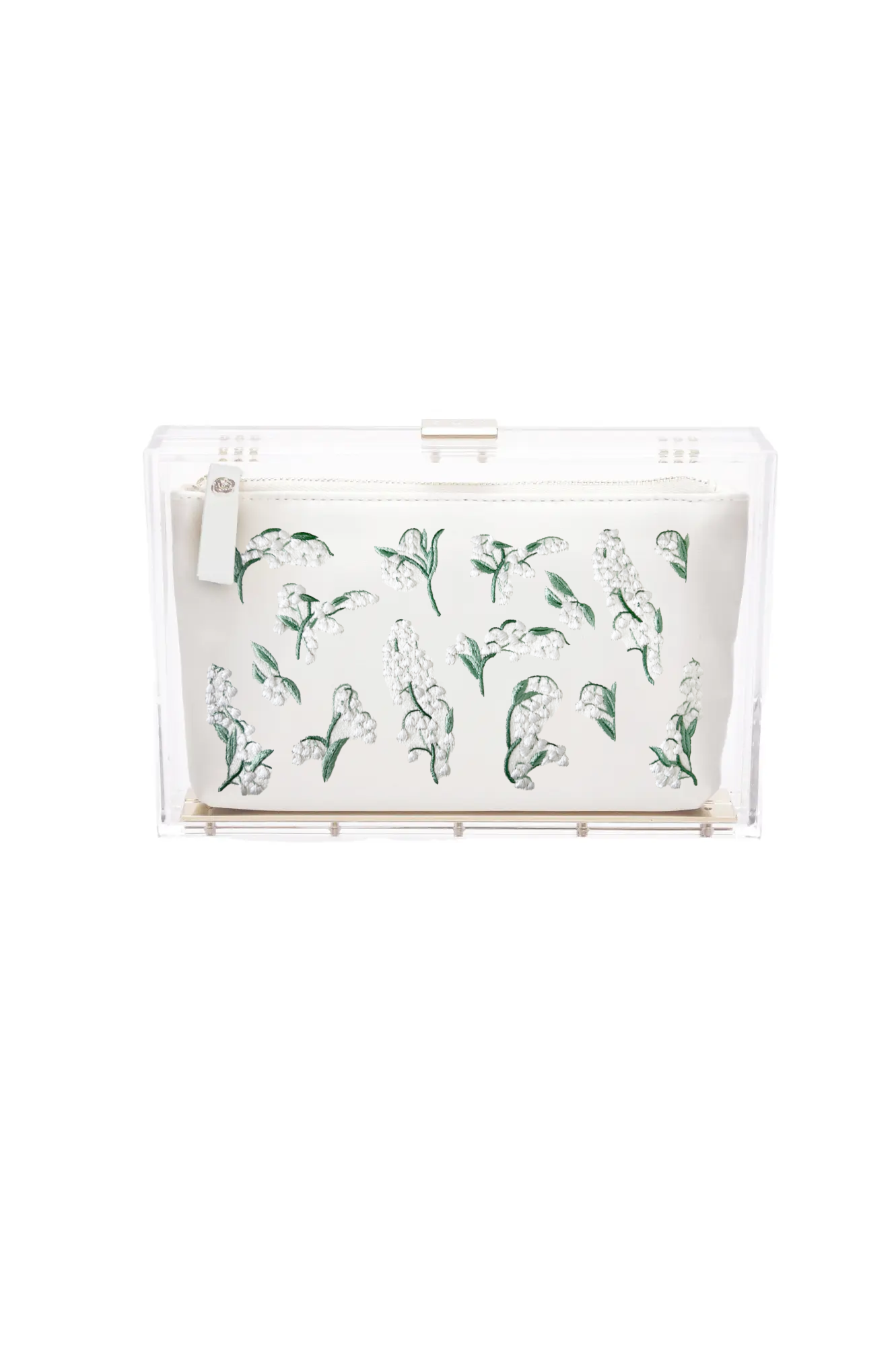 The Mia Acrylic Clutch with Lily of the Valley by The Bella Rosa Collection is an ivory satin pouch adorned with green hand-embroidered flowers, elegantly presented in a transparent box.
