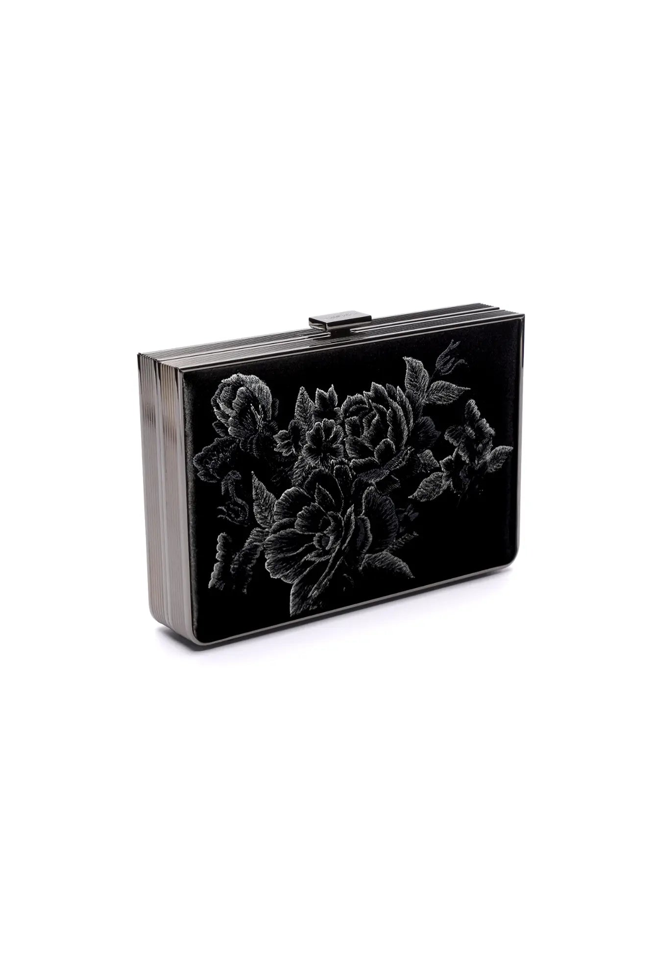Displayed against a white background, the Venezia Clutch x MICAELA from The Bella Rosa Collection features a rectangular black satin design with silver floral embroidery on the front and a silver clasp. Don’t miss this exquisite piece available at our Sample Sale!