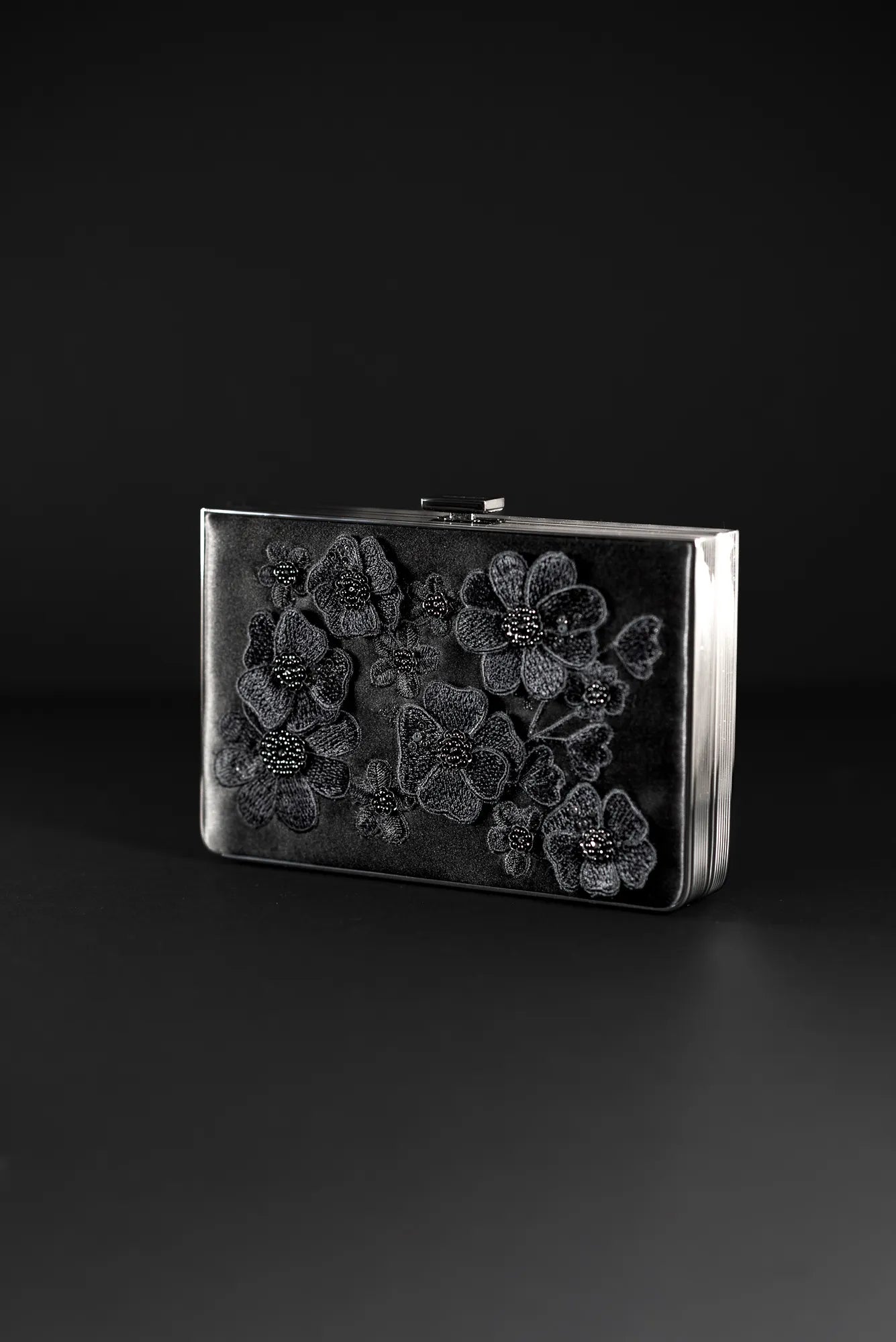 The Bella Rosa Collection's Venezia Clutch x MICAELA in Black Satin Floral Embroidery showcases exquisite 3D floral embroidery on its sleek black surface. Perfect for elegant evenings, it’s a true statement piece. Please note: this is a final sale item.