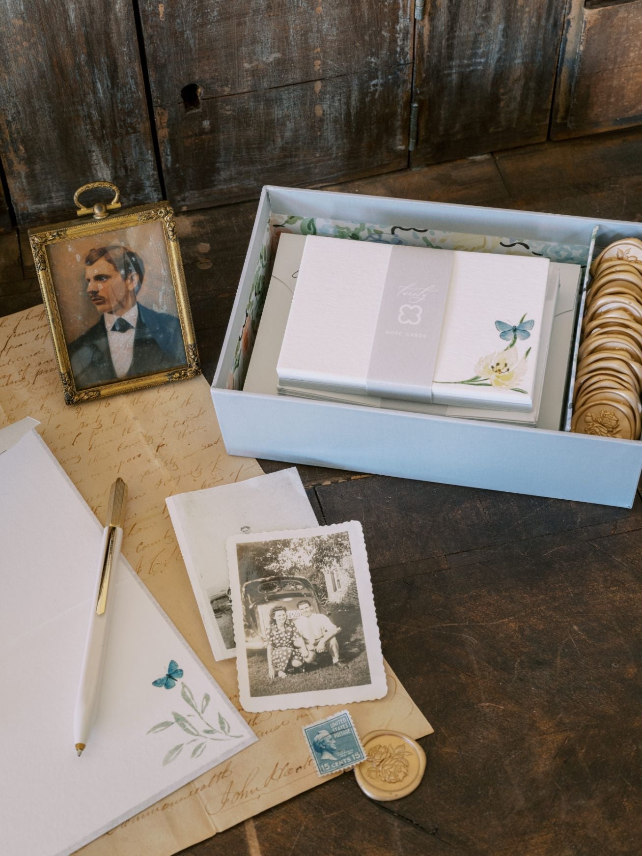 A box with a photo and a notepad on a table, featuring The Bella Rosa Collection's Wedding Day Love Note Box Stationery Set.