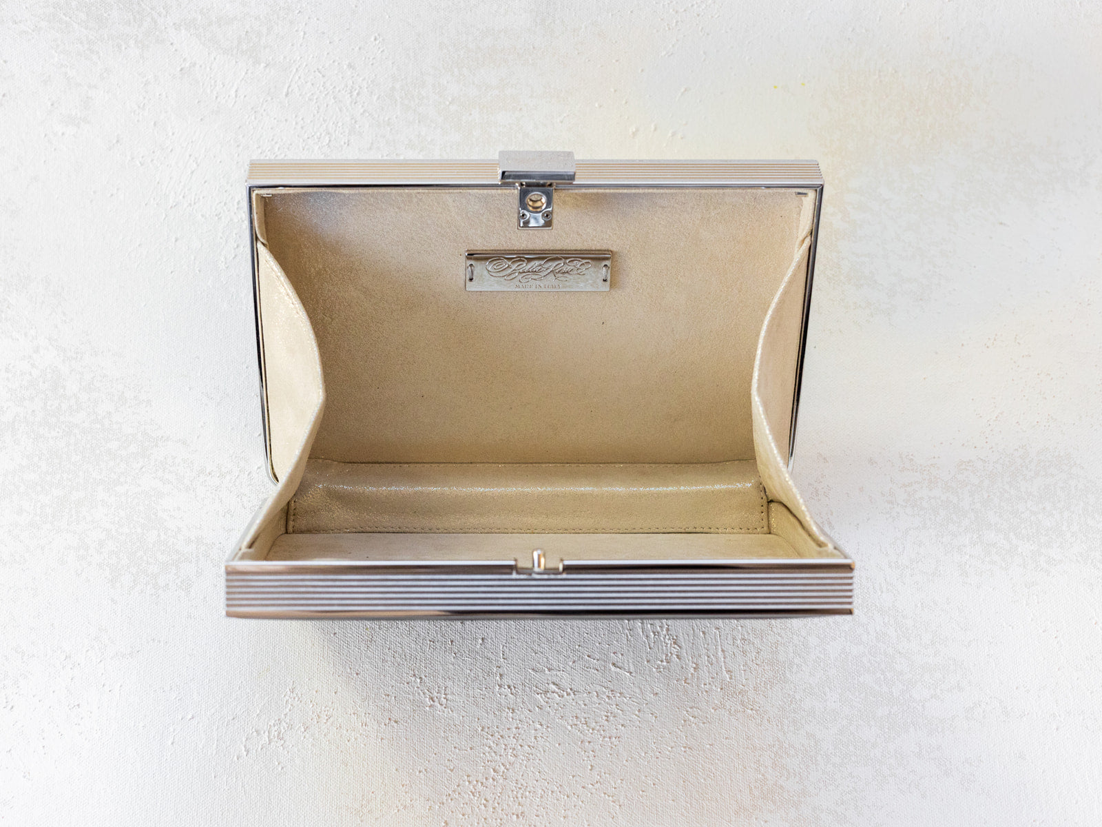 Open view of Venezia clutch with silver rectangle frame and a black leather side.