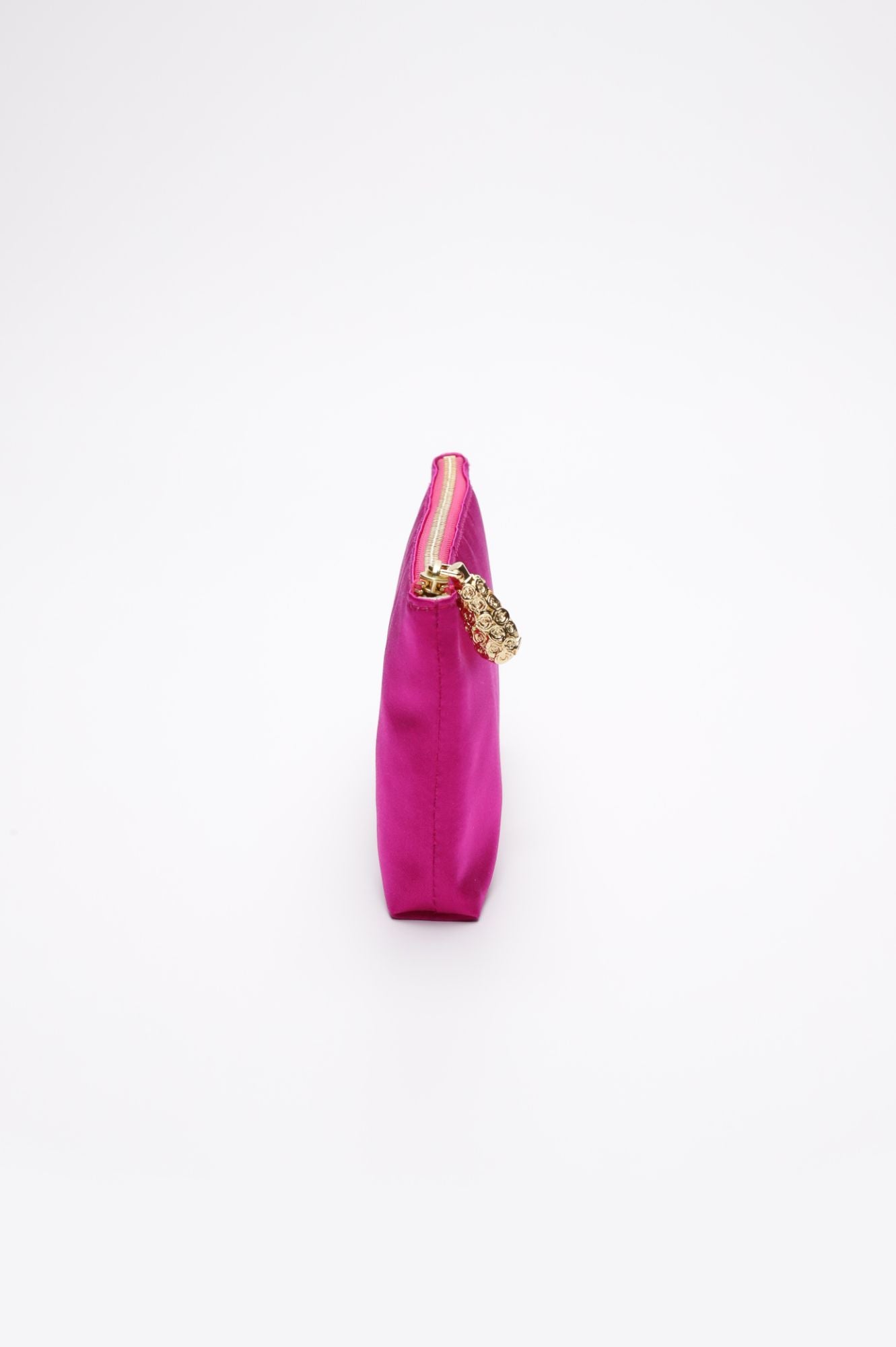 Side view of a small, bright pink Mia Clutch Clear Acrylic with Hot Pink Satin Zipper Pouch, featuring a gold keychain attached to the zipper, available exclusively at The Bella Rosa Collection's sample sale.