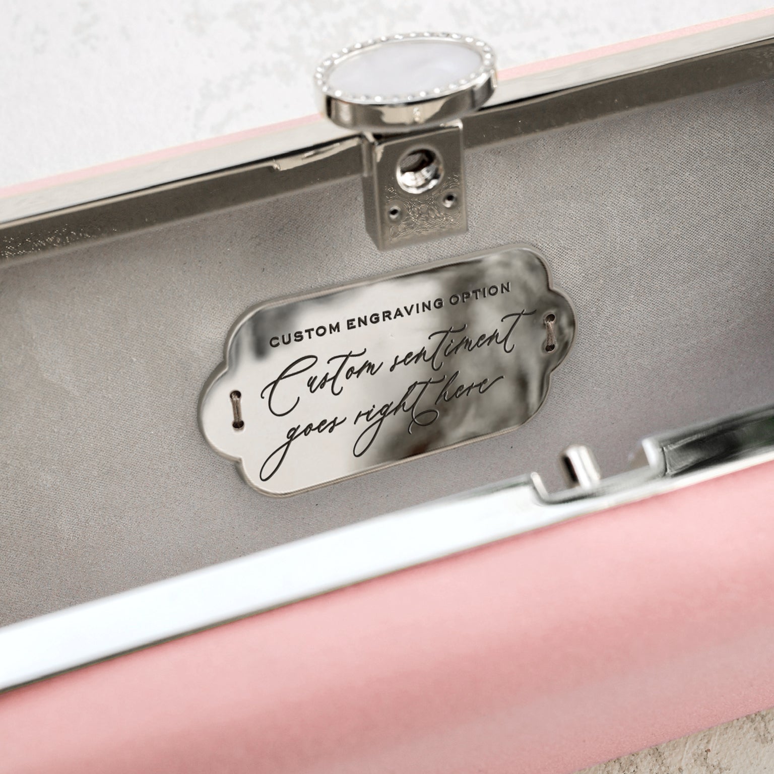 An open jewelry box with a Bella Clutch Pink Petite from The Bella Rosa Collection inside.