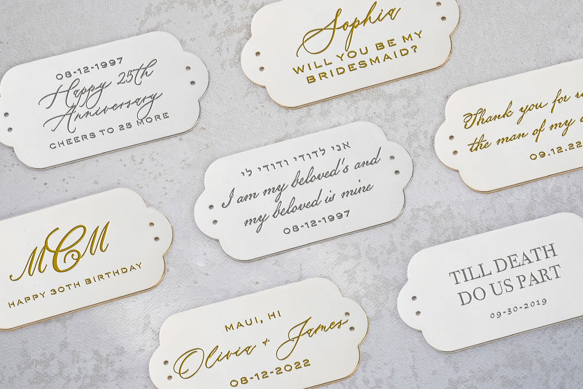 A collection of personalized celebratory cards with gold text and edges on a light surface, each commemorating different special occasions like weddings and anniversaries, including designs inspired by the Bella Clutch Sage Green Satin Petite from The Bella Rosa Collection.
