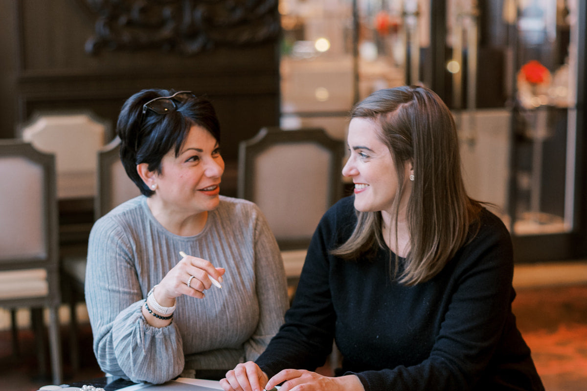 Two women engaged in a pleasant conversation at a table.