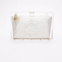 Front view of the clear acrylic Mia body with white satin pouch with bridal crest monogram embroidery.