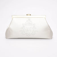 A white vintage bridal clutch with Whyte, monogram embroidery and white, Bridle crest embroidery.
