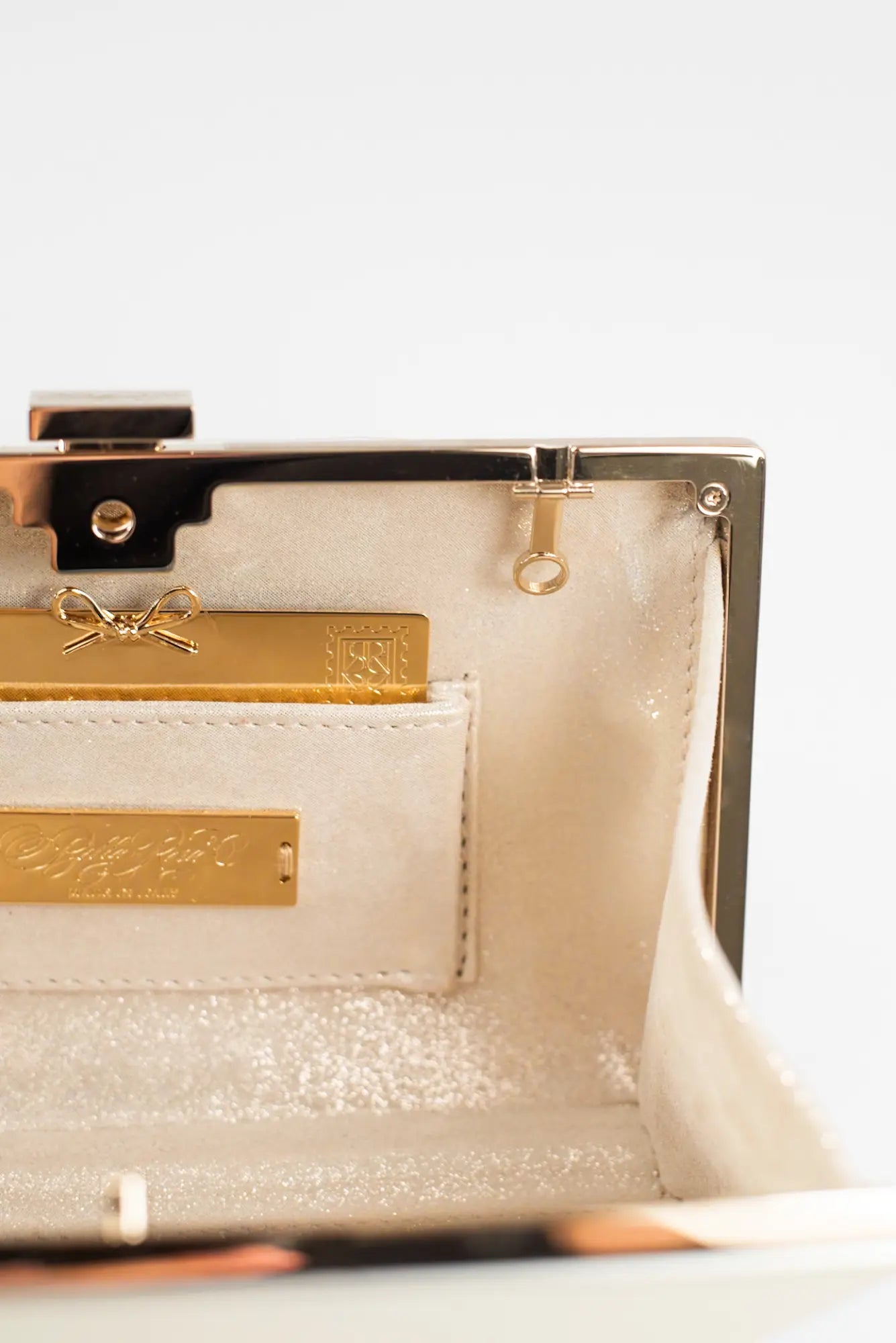 The Bella Rosa Collection&#39;s elegant beige bag features a gold clasp and interior pocket, accompanied by a gold card with embossed design. Ideal for detail lovers, the card allows sentiment engraving through Personalized Plaque Sentiment Engraving for a personal touch.