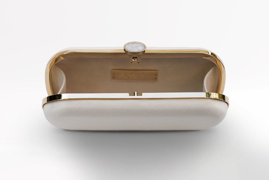 Ivory satin bridal clutch open view with gold hardware accents and a stimulated mother of pearl clasp.