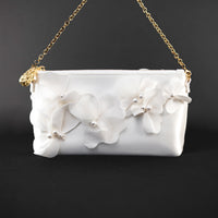 A white Hayden Clutch Purse from The Bella Rosa Collection adorned with Organza Flowers.
