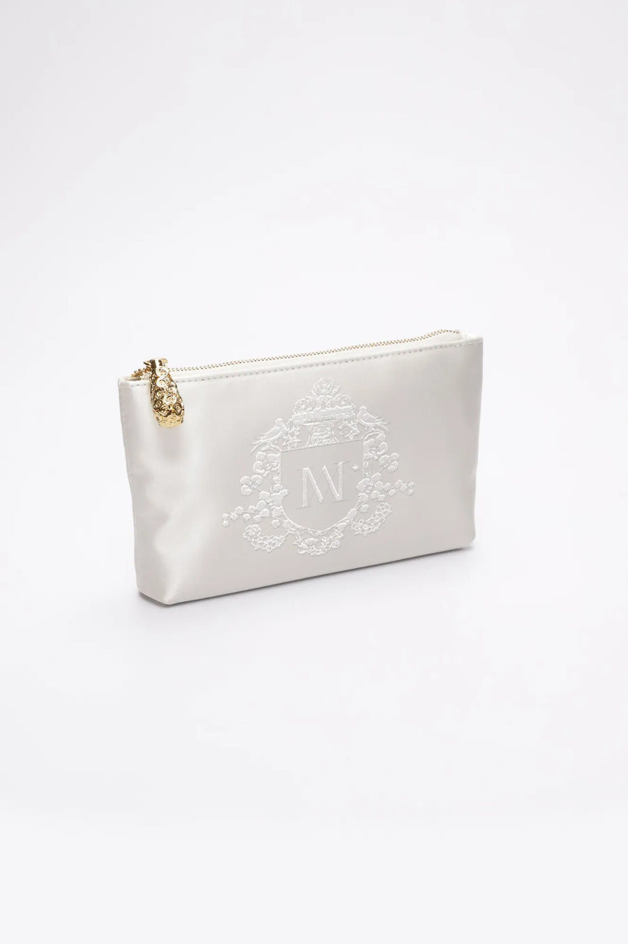 Side view of ivory satin zipper pouch with bridal crest monogram embroidery.
