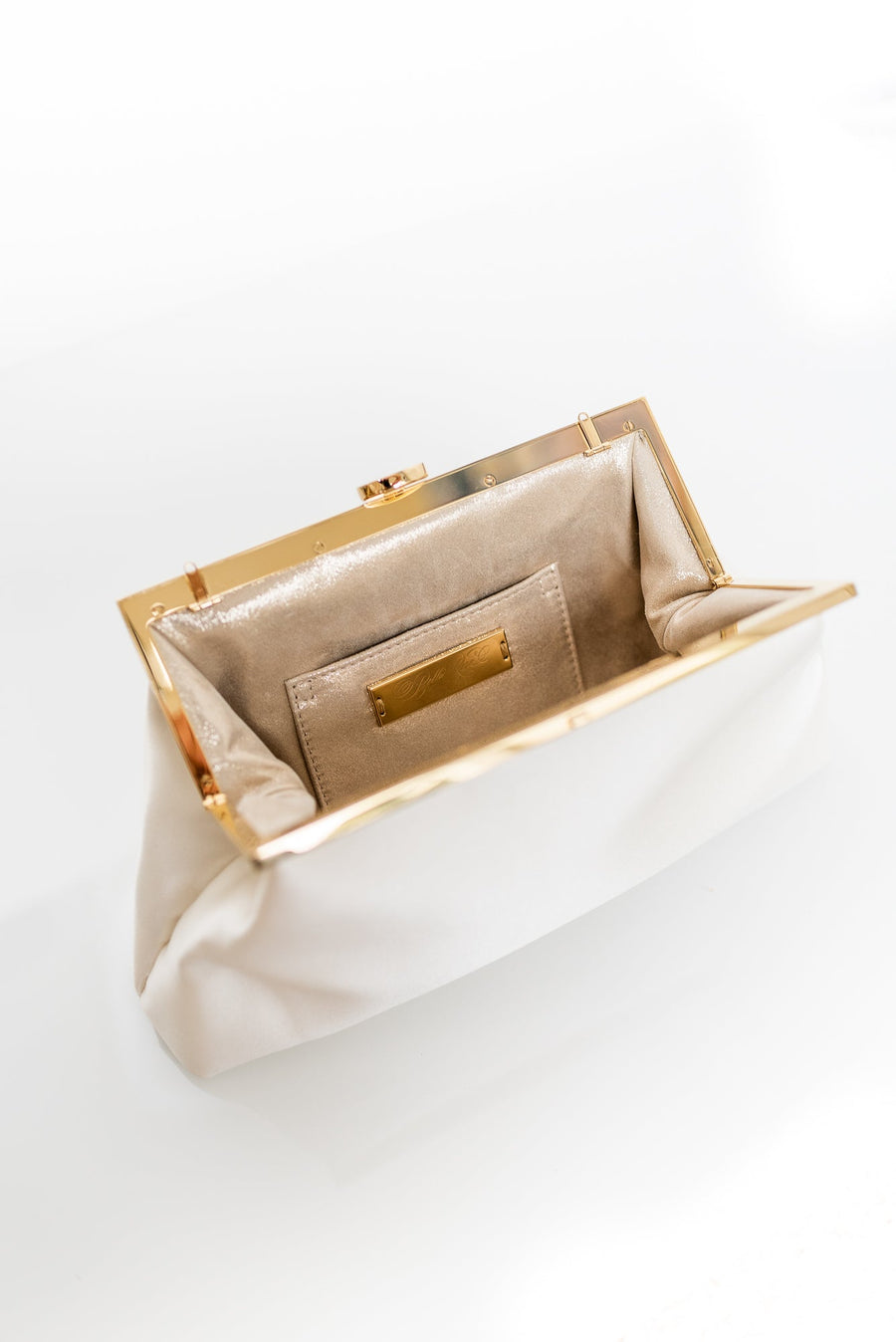 A white and gold Rosa Clutch - Ivory Floral Embroidery from The Bella Rosa Collection on a white surface.
