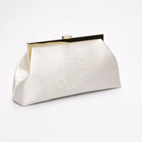 Side angle of a white bridal clutch with Whyte bridal wedding crest, monogram embroidery.