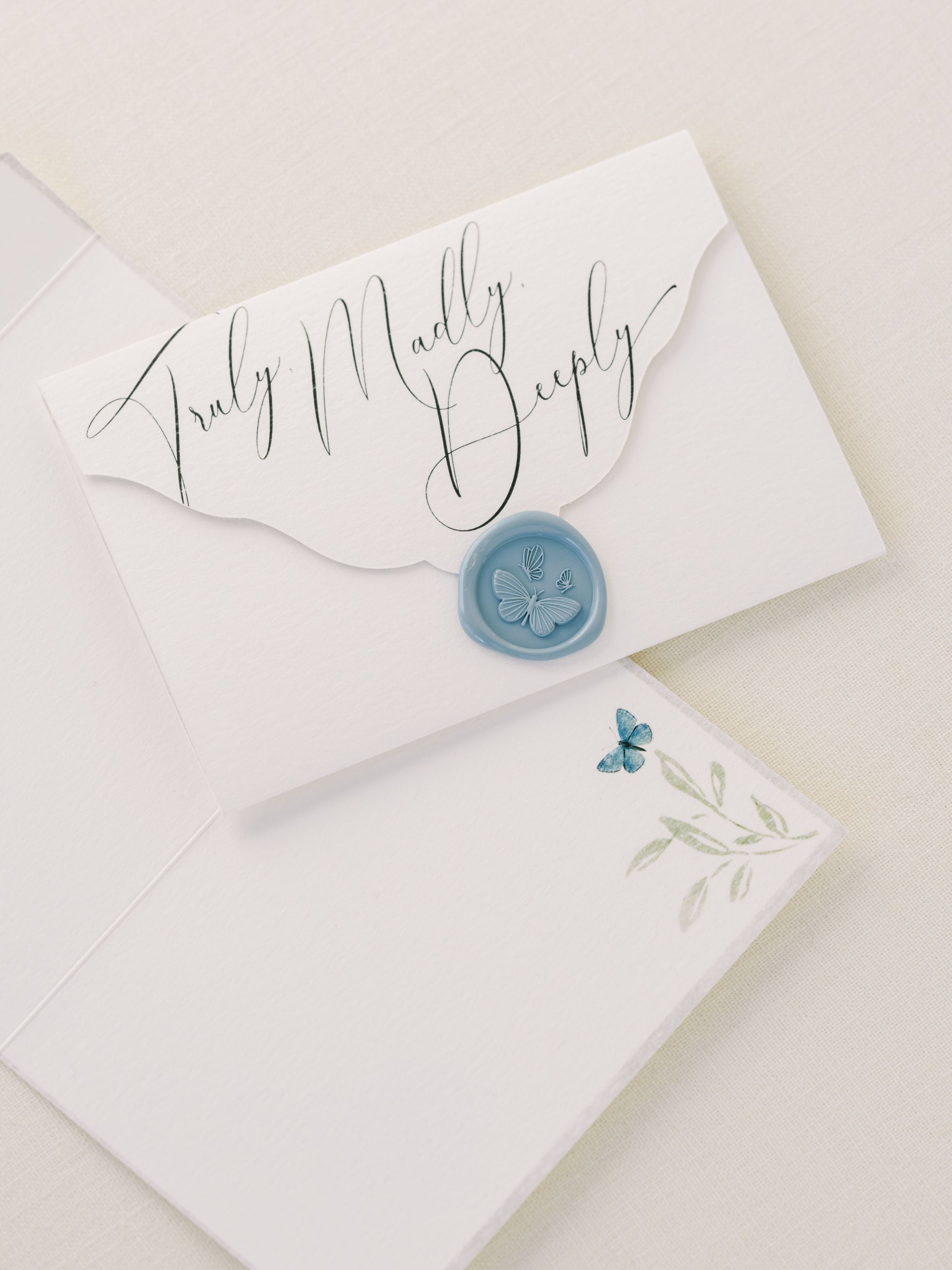 A blue envelope with a wax seal on it, containing the Wedding Day Love Note Box Stationery Set from The Bella Rosa Collection for your wedding day stationery.