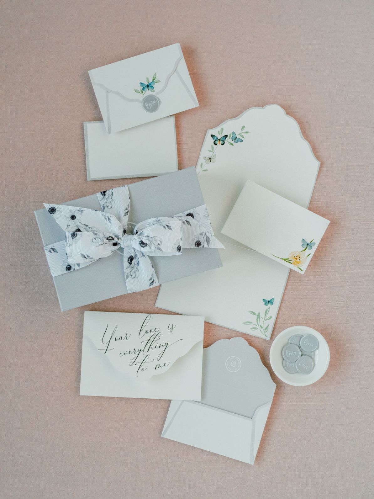 A set of Wedding Day Love Note Box Stationery Set featuring watercolor floral motif note cards with a bow on them from The Bella Rosa Collection.