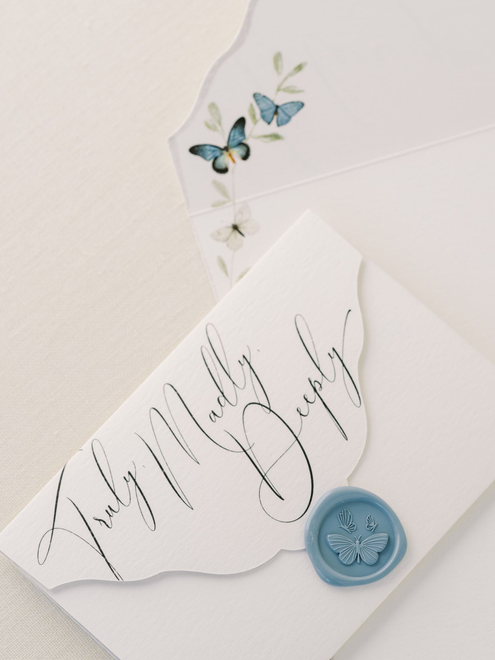 A blue envelope with a wax seal and butterflies on it, perfect for The Bella Rosa Collection&#39;s Wedding Day Love Note Box Stationery Set.