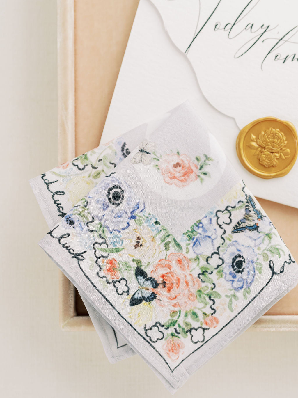 A close up of The Bella Rosa Collection&#39;s Wedding Floral Handkerchief and a coin in a box.