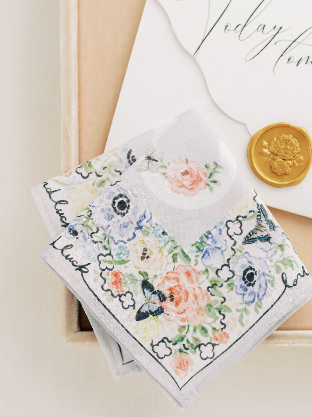 A close up of The Bella Rosa Collection's Wedding Floral Handkerchief and a coin in a box.