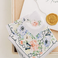 A close up of The Bella Rosa Collection's Wedding Floral Handkerchief and a coin in a box.