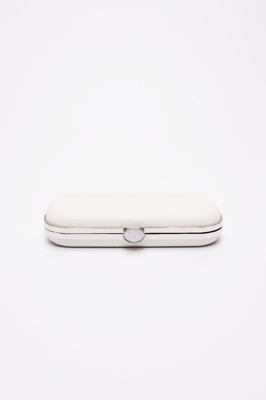Bella Clutch in a shimmer white glitter body with a silver frame laying on side showing top clasp angle.