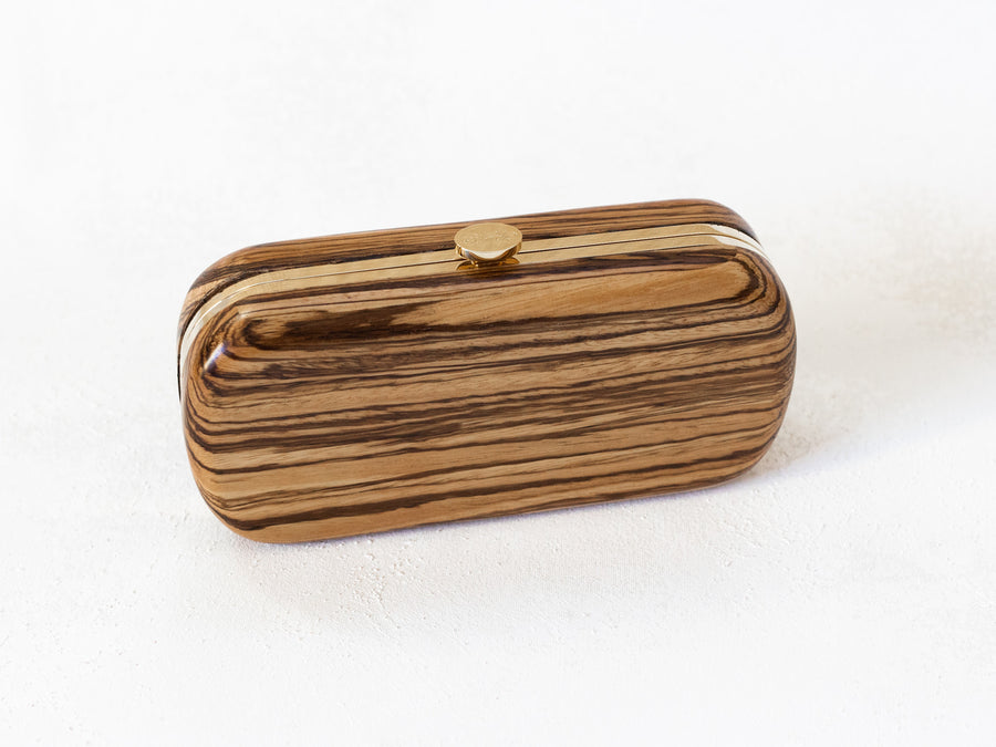 Sustainably sourced Bella Clutch African Zebra Wood Petite with swirl grain pattern and gold-tone clasp from The Bella Rosa Collection.