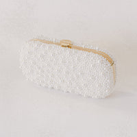 An Over the Moon True Love Bella Pearl Clutch on a white surface.