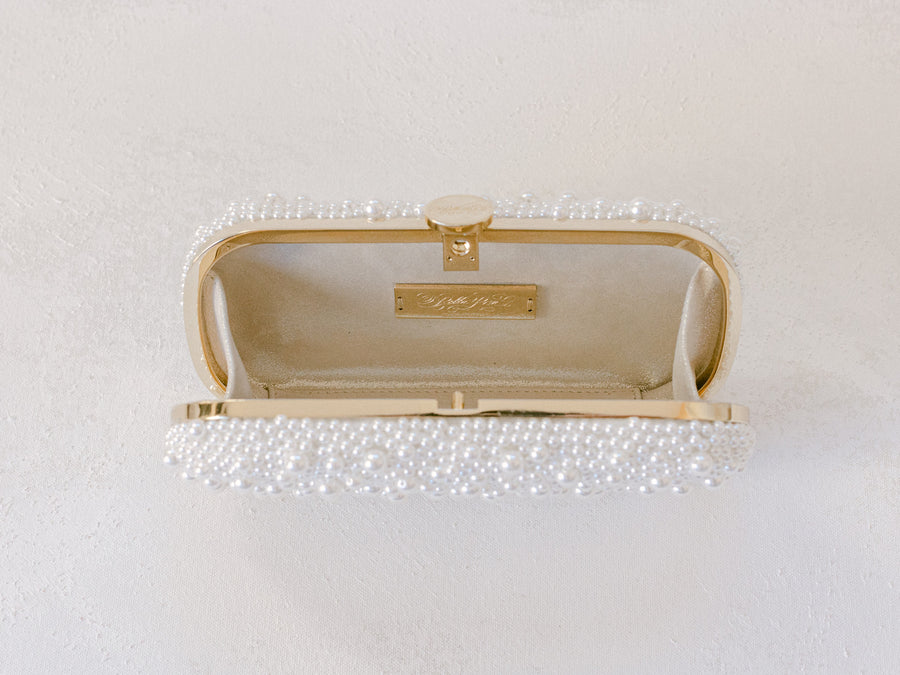 An Over the Moon True Love Bella Pearl Clutch hanging on a wall.
