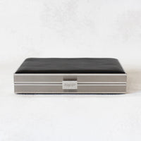 Top side view of Venezia clutch with silver rectangle frame and a black leather side.