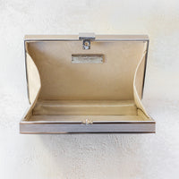 Open view of Venezia clutch with silver rectangle frame and a black leather side.