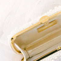 An Over the Moon True Love Bella Pearl Clutch with a bow.