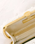 An elegant True Love Pearl Petite Bella Clutch from The Bella Rosa Collection, adorned with pearls, partially obscured by a translucent white fabric.