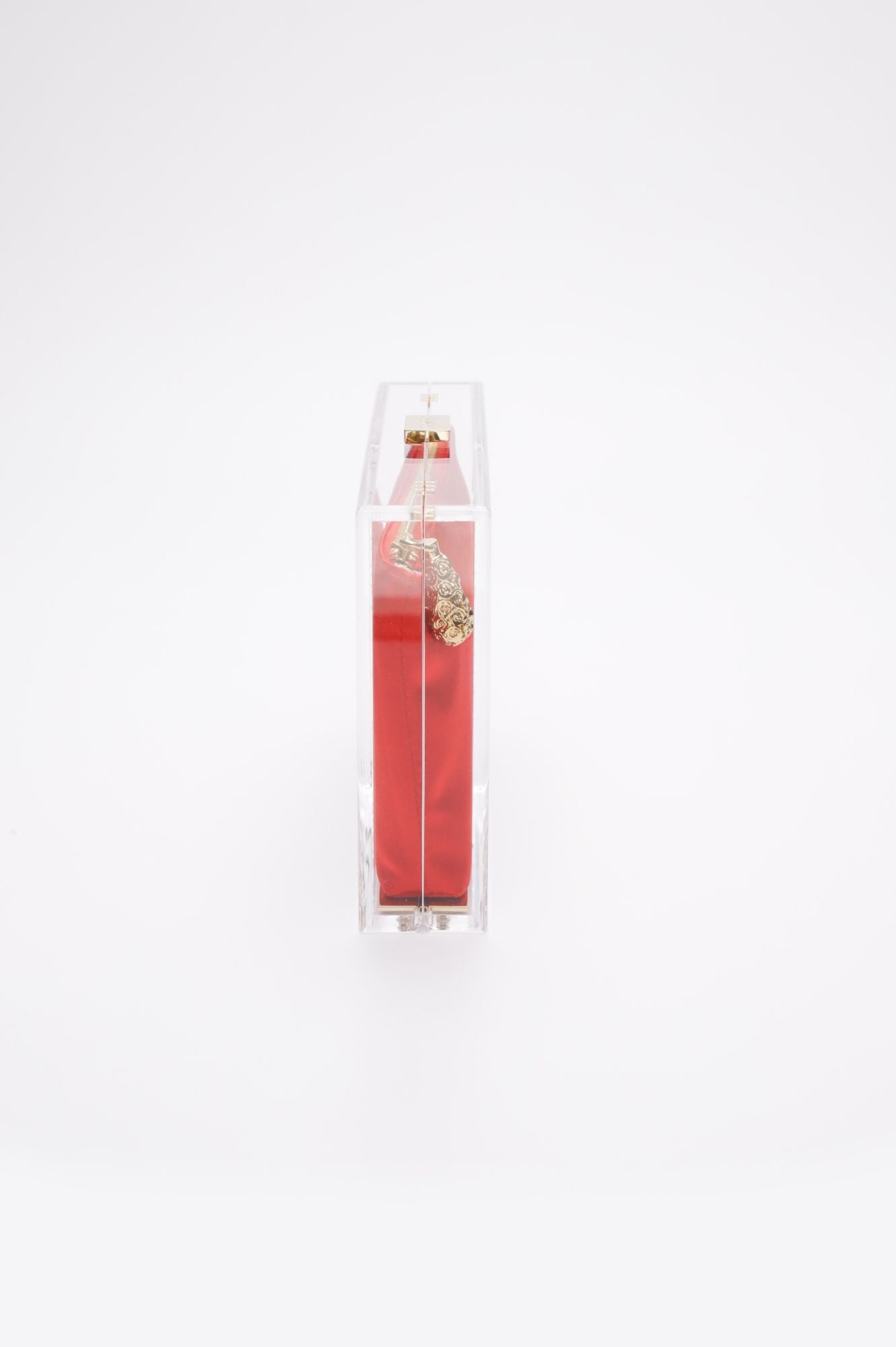 A clear acrylic display case with a red satin zipper pouch inside, captured from the side. The case stands against a white background, reminiscent of an exclusive Mia Clutch Clear Acrylic with Red Satin Zipper Pouch from The Bella Rosa Collection showcased at a sample sale.