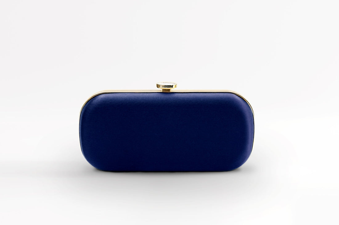 Front view of bridal Bella Clutch in dark navy blue with gold hardware accents and stimulated mother of pearl clasp.