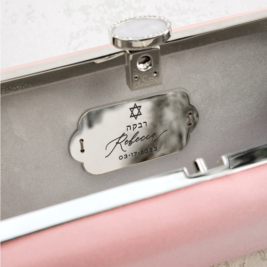 A personalized gift - the Bat Mitzvah Personalized Bella Clutch Petite, an elegant pink leather case with a silver plate on it from The Bella Rosa Collection.