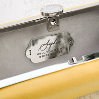 A customized yellow Bridesmaid Proposal Box with an Engraved Bella 'Be My Bridesmaid' Clutch Bag Gift, perfect for a bridesmaid proposal from The Bella Rosa Collection.