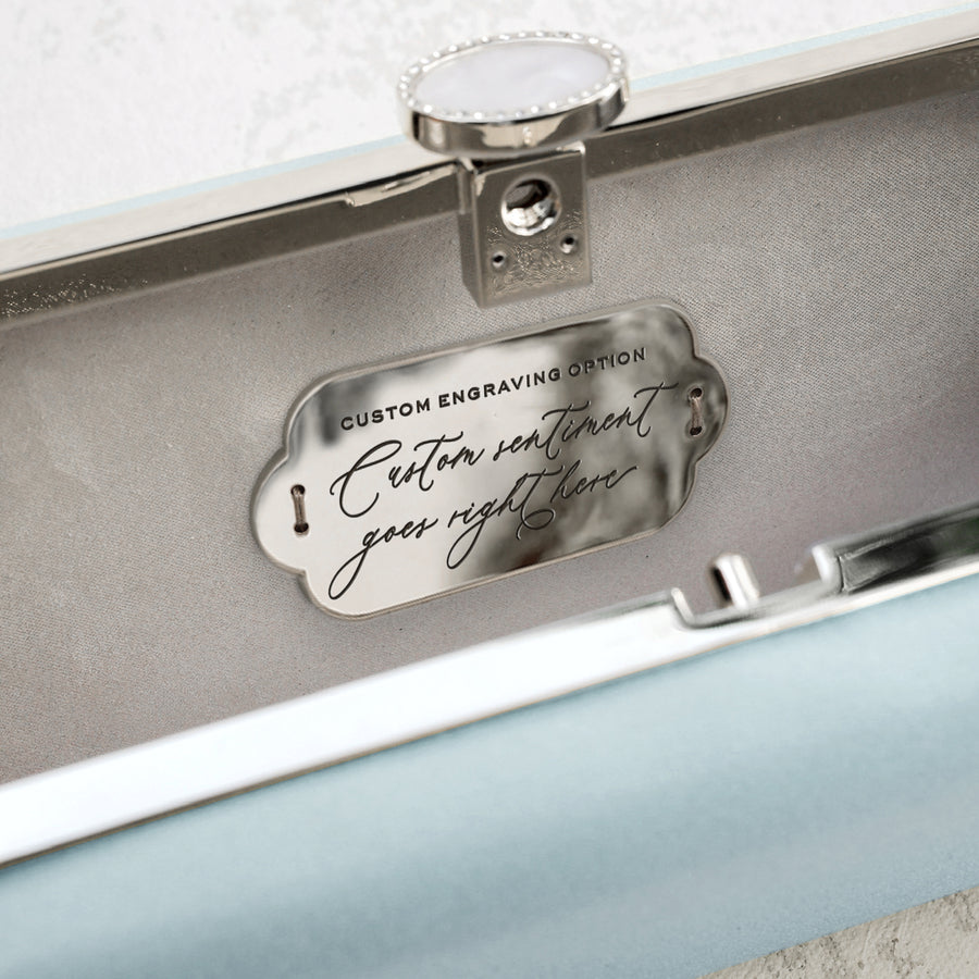 A Cinderella Blue Satin Bella Clutch from The Bella Rosa Collection with a silver plaque on it.