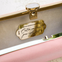 The Bat Mitzvah Personalized Bella Clutch Petite, a personalized gift perfect for a Bat Mitzvah, is an elegant pink clutch adorned with a gold plaque from The Bella Rosa Collection.