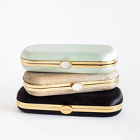 three Black Satin Bella Clutches from The Bella Rosa Collection stacked on top of each other.
