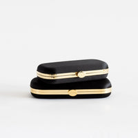 Bella Clutch in petite and grande stacked on top of each other to show size difference of 1/2 inch.
