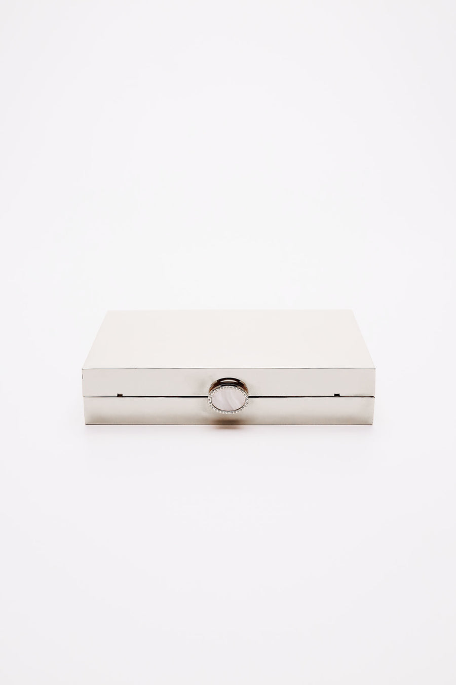 Talich clutch in reflective silver mirror laying on its side, showing the top clasp with a mother of pearl and crystal lined clasp.