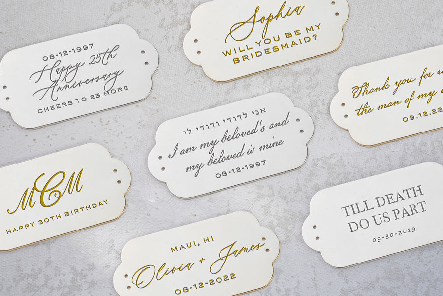 Wedding favor tags with gold and silver lettering, made from Cinderella Blue Satin Bella Clutch by The Bella Rosa Collection.