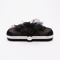 Side closed view of Bella Fiori Clutch in black satin with black flower adored on front side.