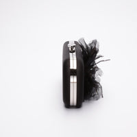 A Black Satin Bella Fiori Clutch from The Bella Rosa Collection with a feather on it.