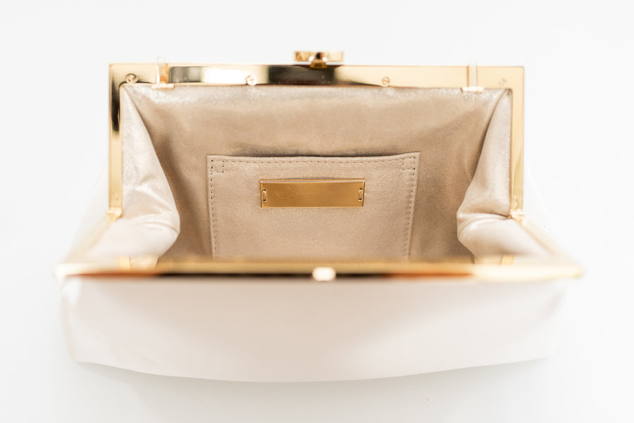 Open view of Rosa Clutch in Ivory white satin with gold hardware clasp frame.