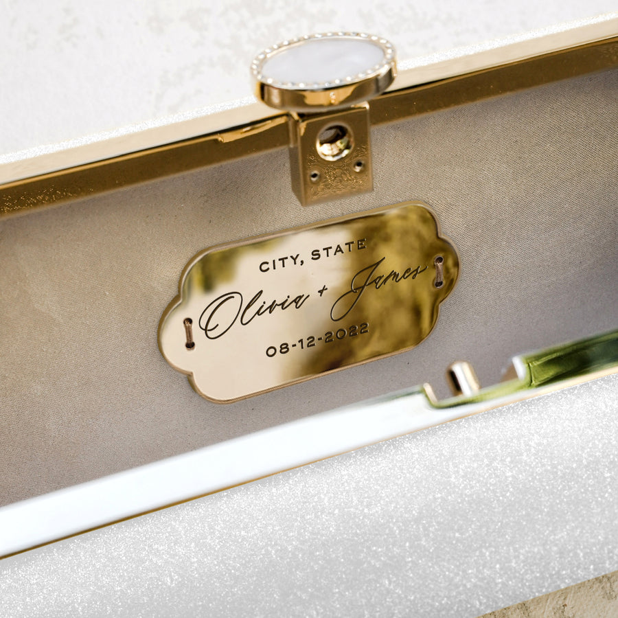 a Snow White Shimmer Bella Clutch with a label on it from The Bella Rosa Collection.